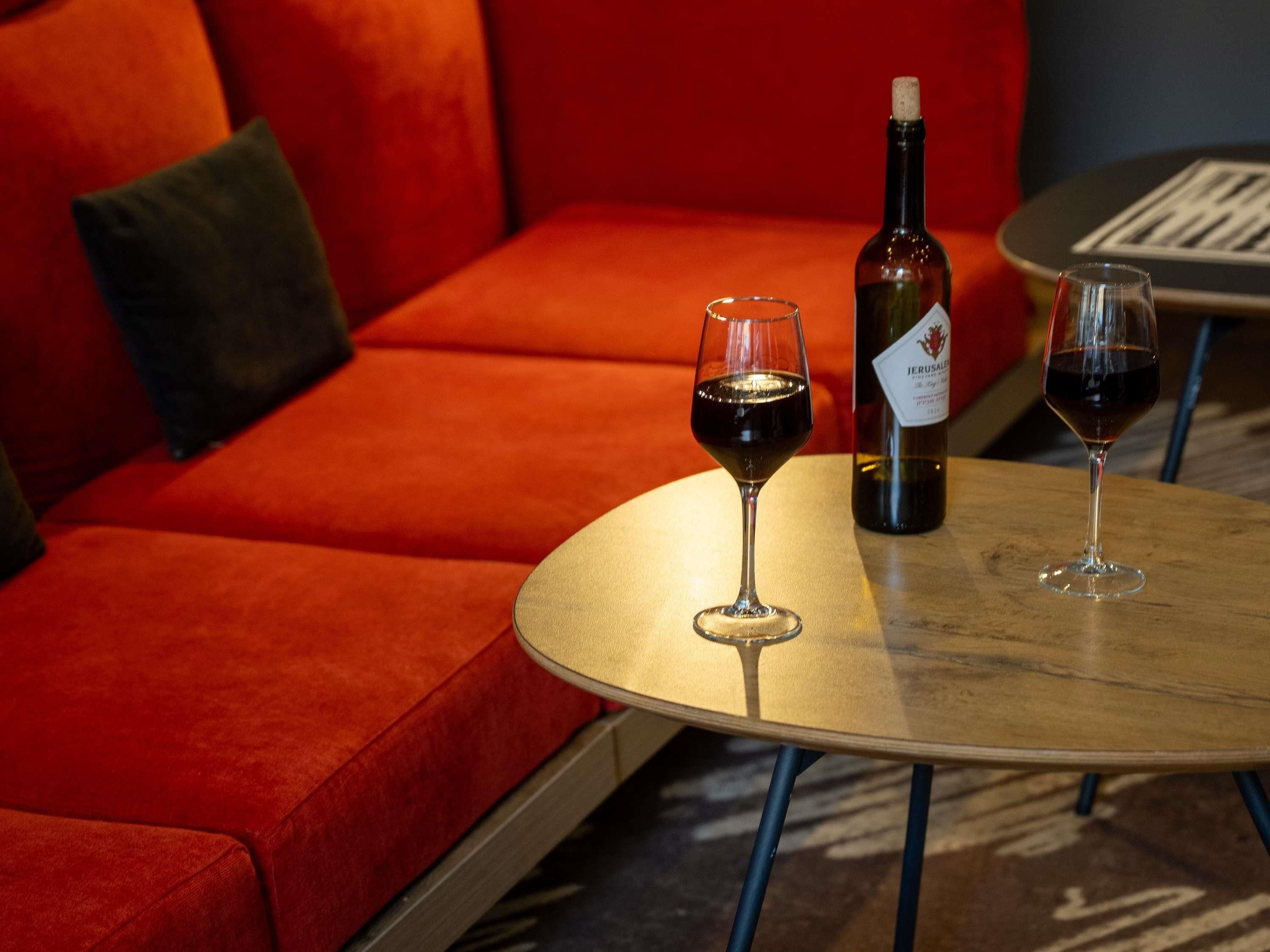 A round table with two wine glasses and a bottle of wine.