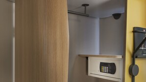 A modern bathroom with a wooden vanity, a built-in microwave, and a towel rack.