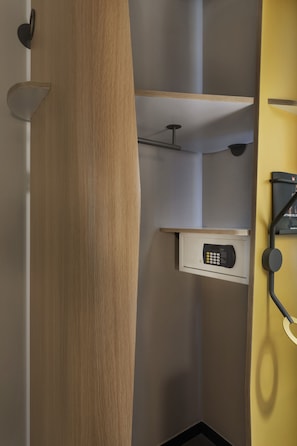 A modern bathroom with a wooden vanity, a built-in microwave, and a towel rack.
