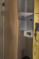 Un baño moderno con tocador de madera, microondas integrado y perchero.
