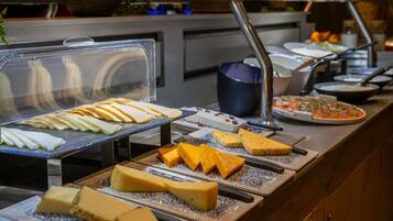 A buffet with various cheeses and a pizza.