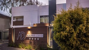 The exterior of Adelante Lodge with a modern design, a signboard with the lodge's name and a five-star rating, and a well-maintained garden area. - Adelante Lodge (Bloemfontein)