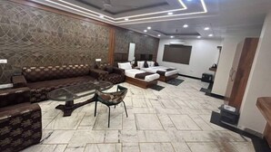 Una sala de estar moderna con un sofá modular, una mesa de centro de vidrio y un televisor de pantalla plana.