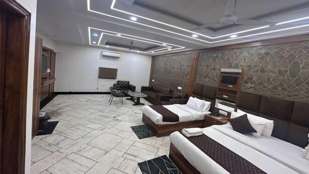 Habitación de hotel con diseño moderno, que incluye una cama grande, un sofá, un escritorio y una silla.