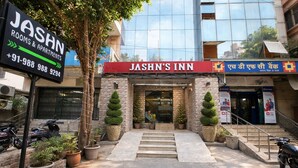 A building with a sign for 'JASHN ROOMS & APARTMENTS' and 'JASHN'S INN' with a staircase leading to the entrance. - Hotel Jashn Inn near Apollo Hospital, Delhi (New Delhi)