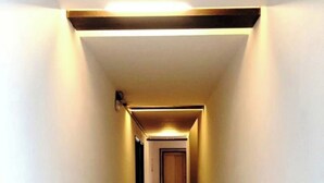 A narrow, well-lit hallway with a wooden door at the end. - Hotel Jashn Inn near Apollo Hospital, Delhi (New Delhi)