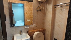 A bathroom with a toilet, sink, and shower.