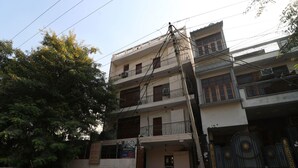 A multi-story residential building with balconies, a gated entrance, and a parked scooter. - Royal Palce (new Delhi)