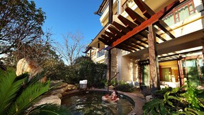 A traditional building with a wooden pergola, a swimming pool, and lush greenery. - HUALUXE Kunming by IHG (Kunming)