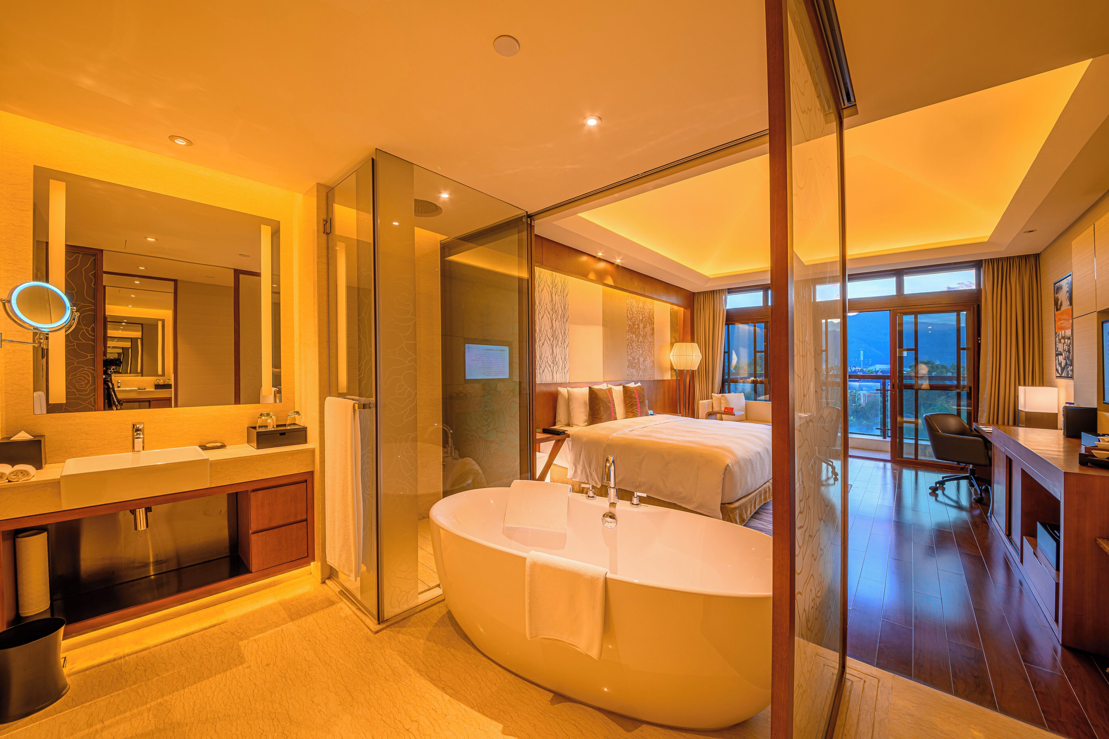 A modern hotel bathroom with a large bathtub, a separate shower area, and a glass-enclosed walk-in shower.