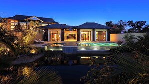 Una casa moderna con piscina, ampie finestre e un ingresso luminoso.