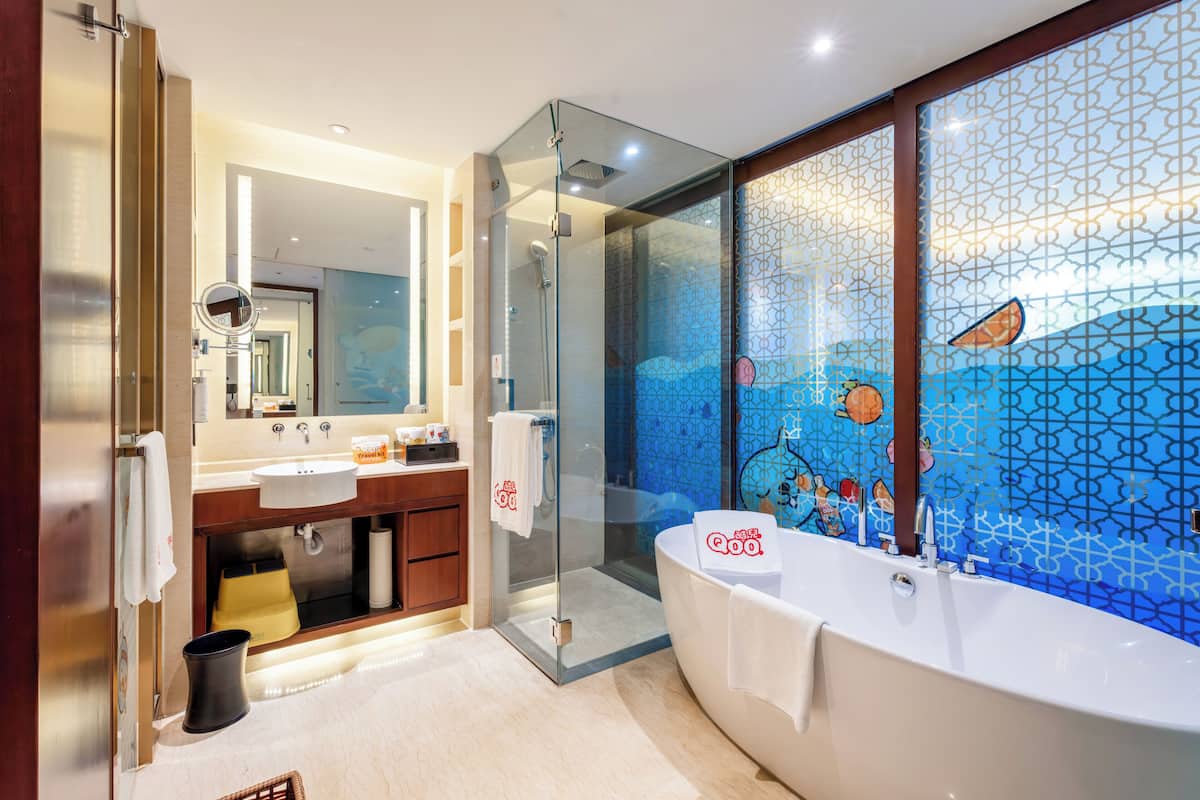 A modern bathroom with a glass-enclosed shower, a large bathtub, and a vanity with a mirror.