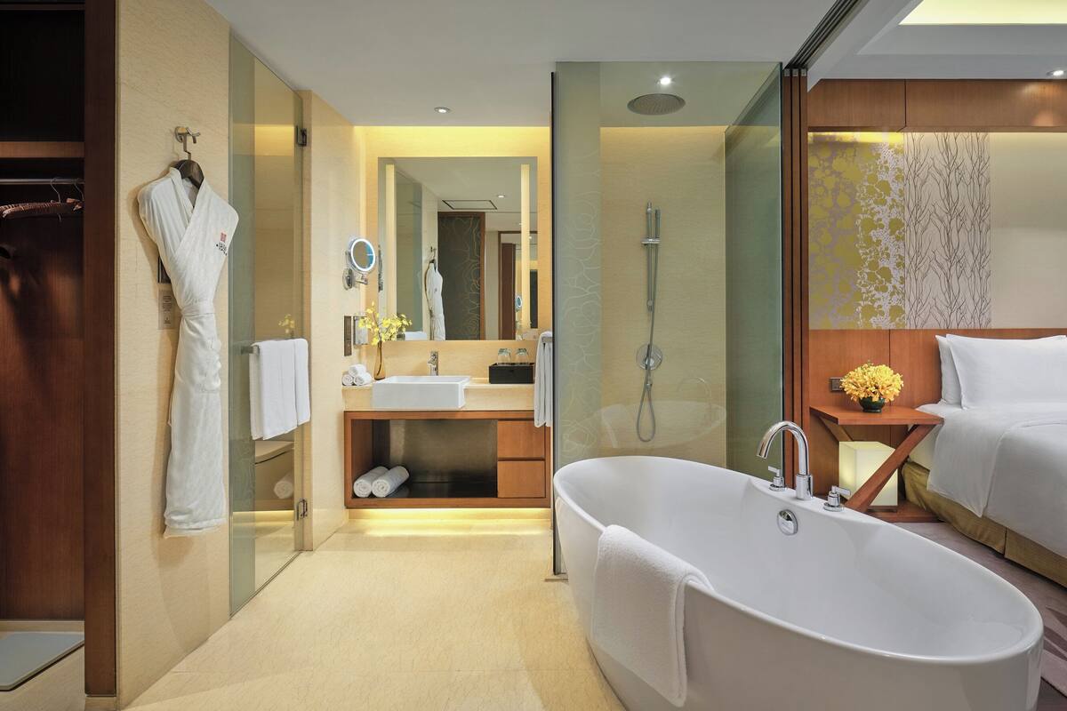 A modern bathroom with a freestanding bathtub, a vanity with a mirror, and a shower area.