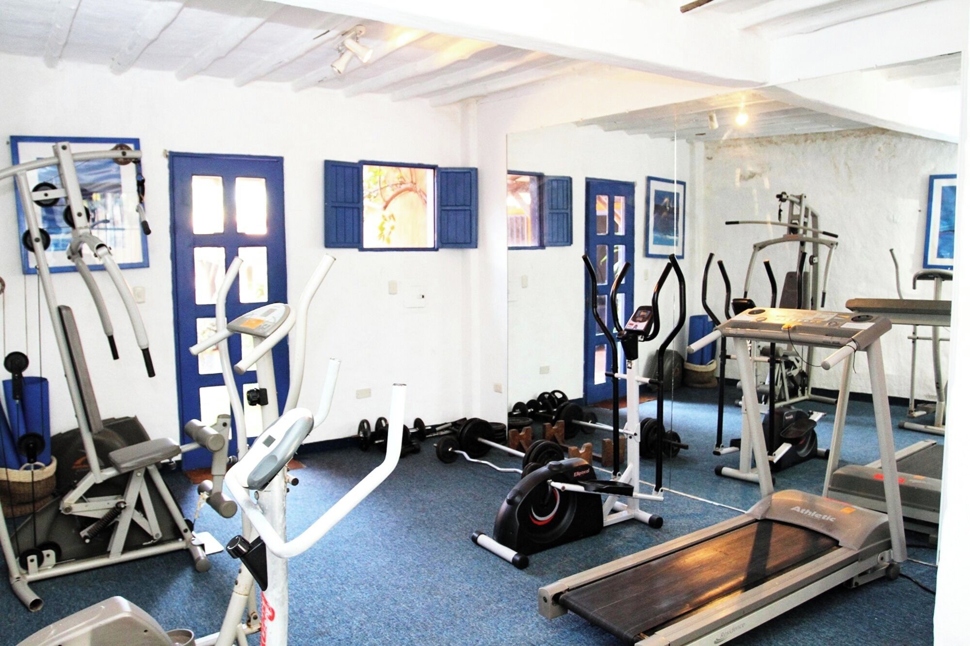 A gym with various exercise equipment, including treadmills, stationary bikes, and weight machines.