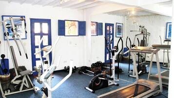 A gym with various exercise equipment, including treadmills, stationary bikes, and weight machines.