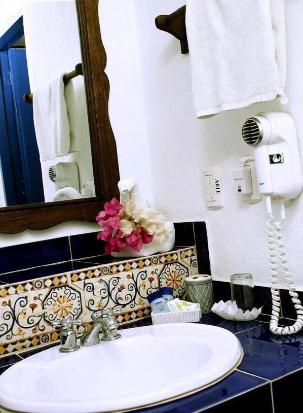 A bathroom with a white sink, a mirror, a hairdryer, and a telephone. - Costa Linda Beach  (Paraguachi)