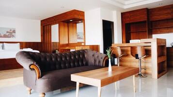 A modern living room with a dark brown sofa, a wooden coffee table, and a wooden sideboard with bar stools.