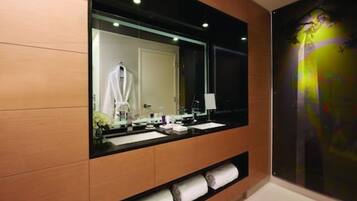 Une salle de bain moderne avec un grand miroir, des meubles en bois et un porte-serviettes.