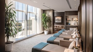 A modern hotel lobby with a seating area, large windows, and potted plants. - MGM National Harbor Resort & Casino (Oxon Hill)