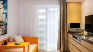 Un salon moderne avec un canapé, une table basse et un téléviseur posé sur un meuble.