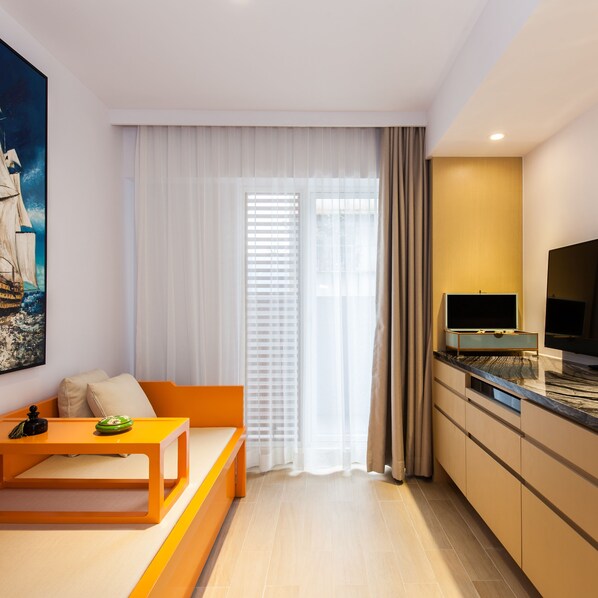 A modern living room with a sofa, a coffee table, and a TV on a cabinet.