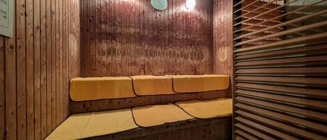 Un banco de madera con cojines en una habitación con paredes de madera y un panel de madera con listones.