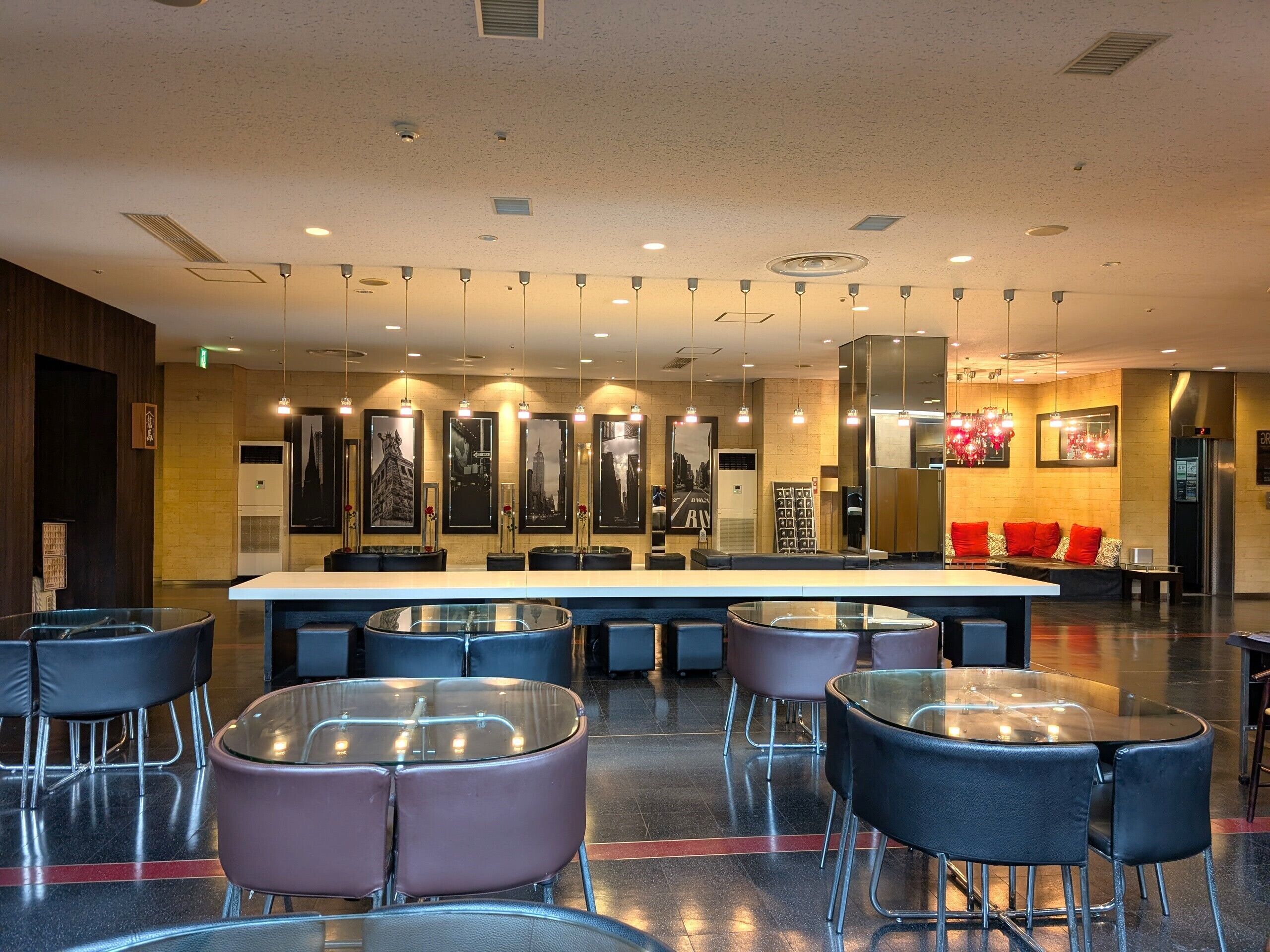Un lobby moderno de hotel con mostrador de recepción, zona de estar y obras de arte en las paredes.