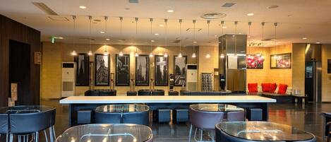 Un lobby moderno de hotel con mostrador de recepción, zona de estar y obras de arte en las paredes.