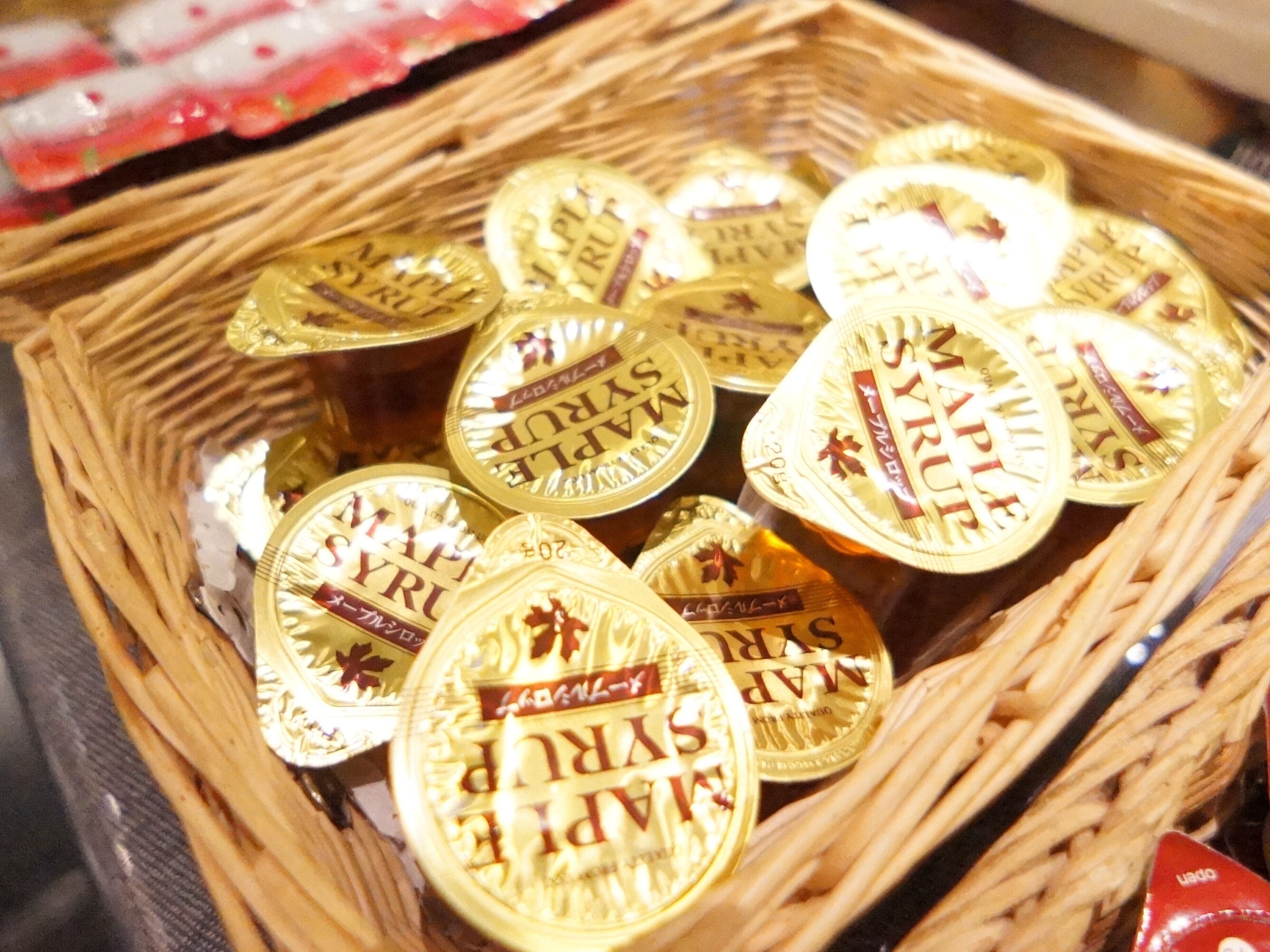 A basket filled with round, gold-colored containers with 'SYRIA' printed on them.