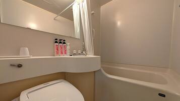 A bathroom with a toilet, a sink, a shower, and a mirror.