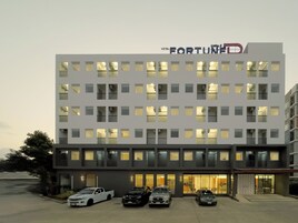 Un edificio de hotel de varios pisos con un llamativo letrero 'FORTUNE' en la parte superior.