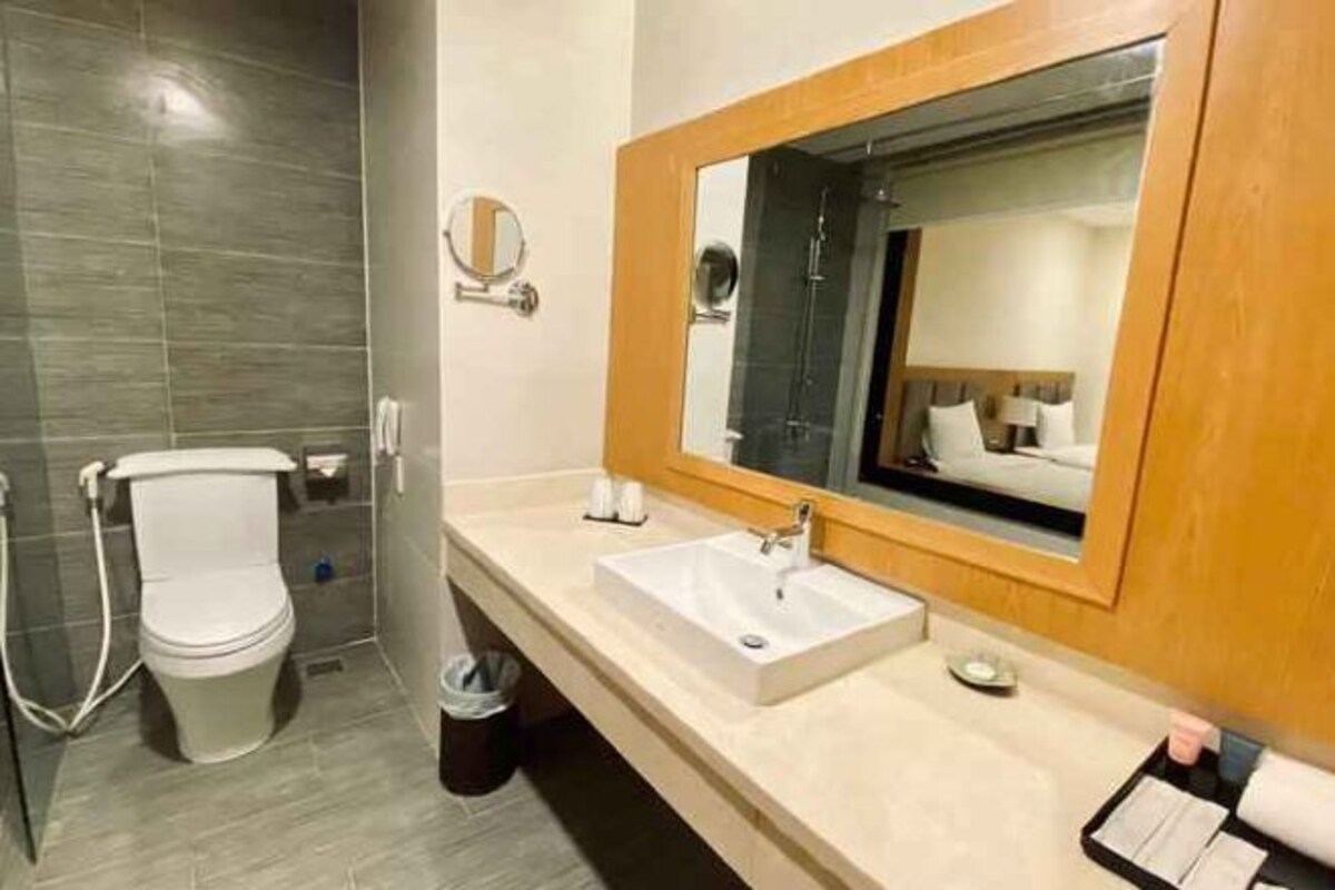 Une salle de bain moderne équipée de toilettes, d’un lavabo et d’un miroir.