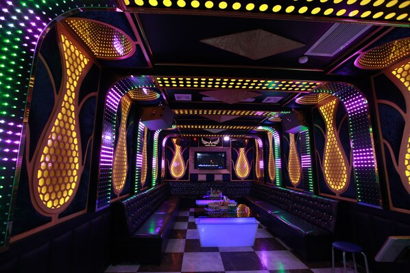 A brightly lit, modern bar with neon lights and a checkered floor.