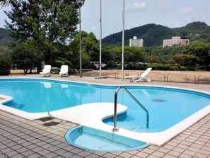 A swimming pool with a small hot tub, surrounded by white lounge chairs and a paved deck. - Hyper Resort Villa Shionoe (Takamatsu)