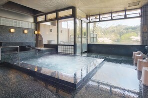 Un área de spa con hidromasaje, asientos y vistas al exterior.