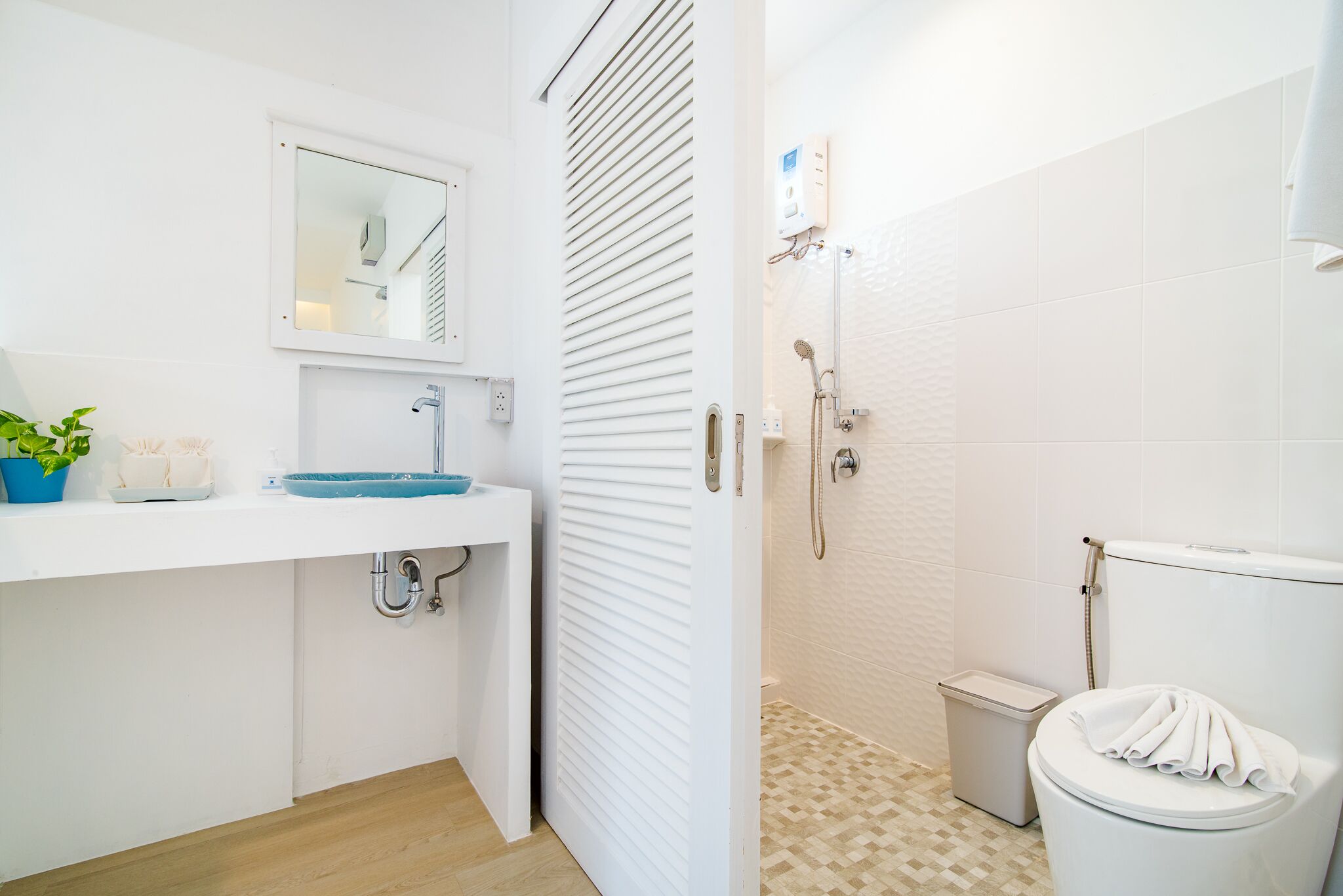 Un baño moderno con un lavabo, espejo y retrete blancos.
