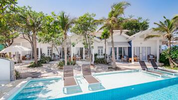 Relax by the pool surrounded by palm trees and lounge chairs.