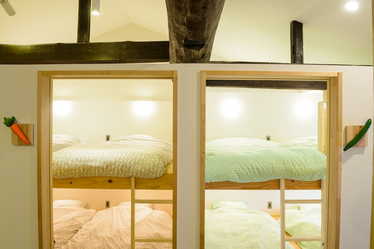 Habitación con literas, dos camas con cubrecamas de distintos estampados.