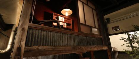 Ein traditioneller japanischer Raum mit Tatami-Böden, einem niedrigen Holztisch und einer hängenden Leuchte.