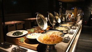 A buffet with various food options, including salads, fruits, and other dishes, with serving utensils and containers. - Hotel Midtown Richardson Kaohsiung Boai (Kaohsiung)