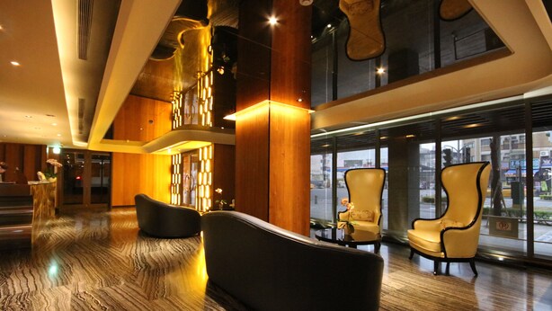 A spacious lobby with a high ceiling, modern furniture, and large windows offering a view of the city. - Hotel Midtown Richardson Kaohsiung Boai (Kaohsiung)