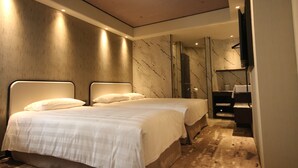 A hotel room with two beds, a large mirror, and a television. - Hotel Midtown Richardson Kaohsiung Boai (Kaohsiung)