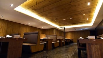 A modern hotel lobby with wooden paneling, seating areas, and a polished marble floor.