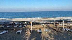 A beach with sun loungers and umbrellas arranged on the sand, facing the sea. - Beldibi Beach Hotel (Kemer)