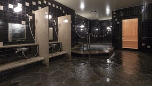 Un bagno moderno con piastrelle bianche e nere a scacchi, pavimento in pietra e uno specchio grande.