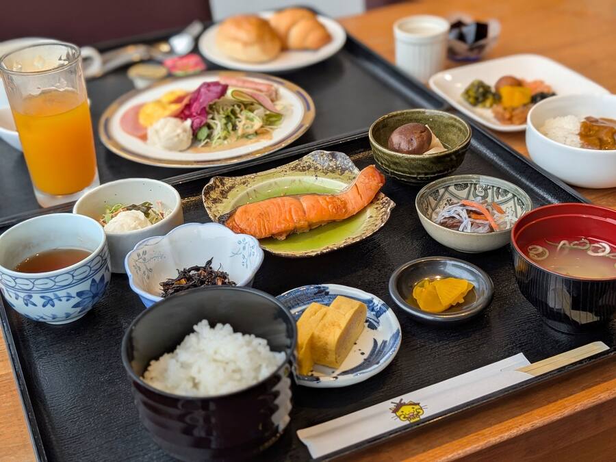 Ein Tablett mit verschiedenen japanischen Gerichten, darunter Sushi, Reis und Suppe.