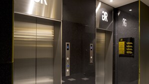 Un ascensore moderno con un display digitale e un cartello che indica le camere degli ospiti.