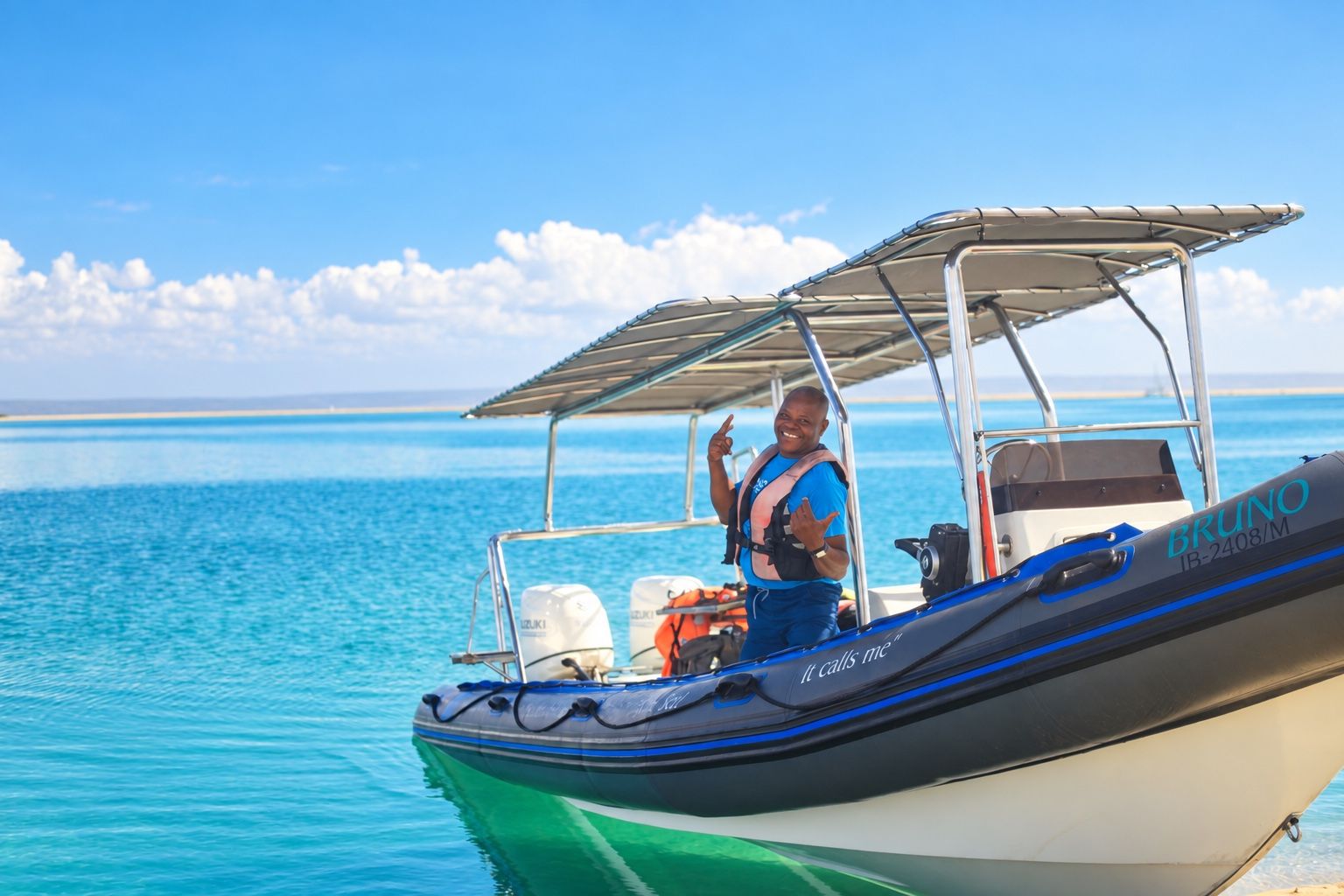 A boat with a person wearing a life jacket, a Suzuki outboard motor, and the name 'BRUNO' on the side.