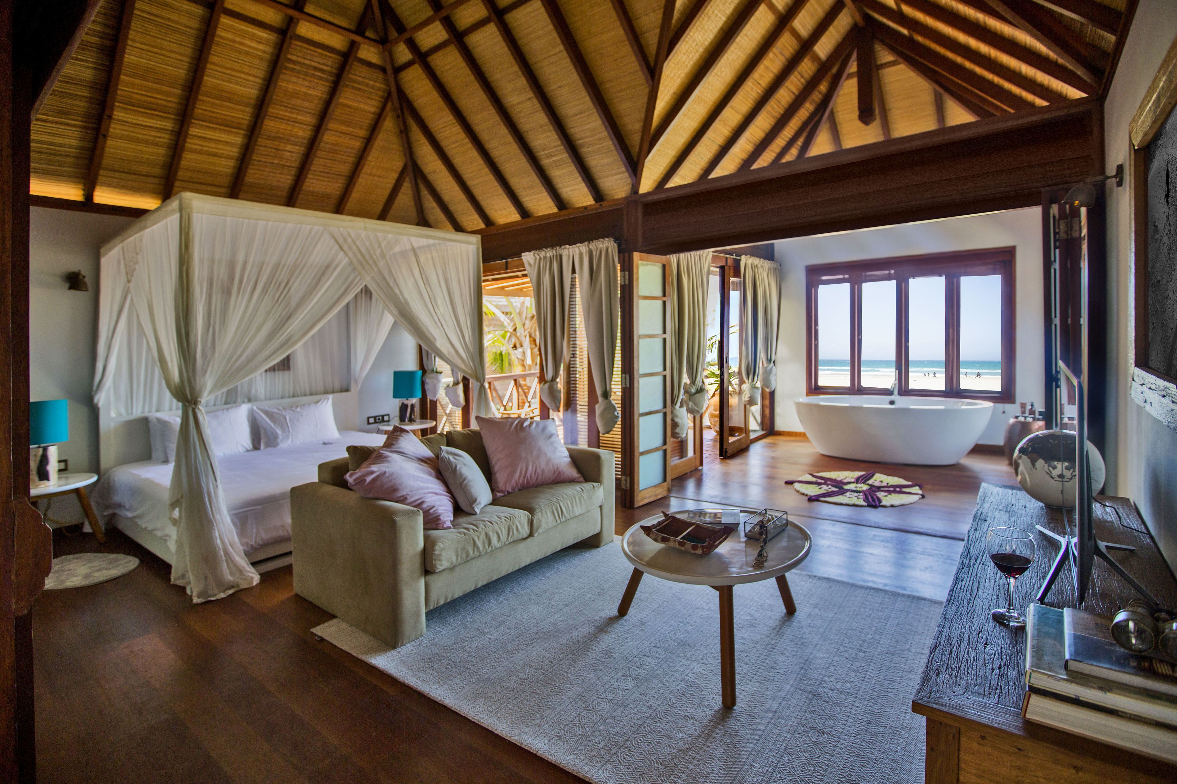 Une chambre avec un lit, un canapé, une table basse et une vue sur la plage.