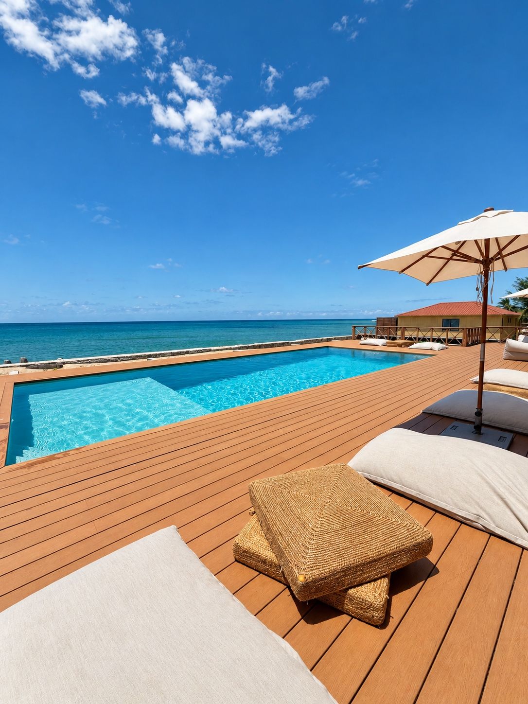 A wooden deck with a swimming pool, lounge chairs, and an umbrella.